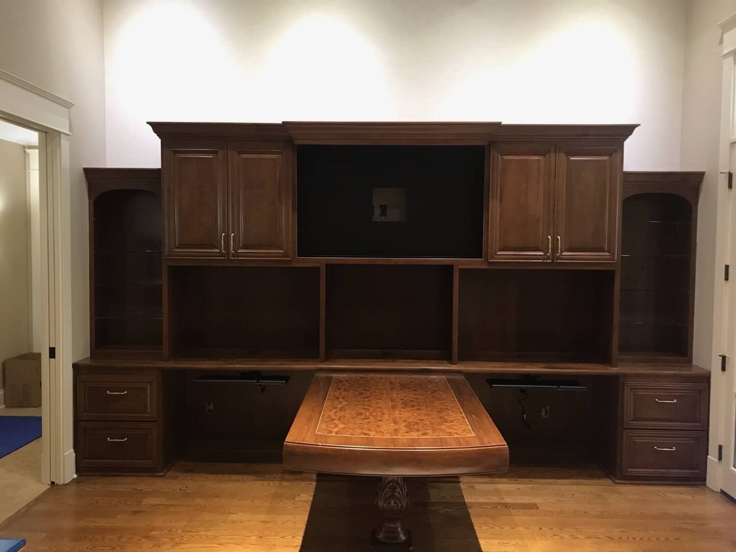 Dark stained custom built-in office wall unit with desk