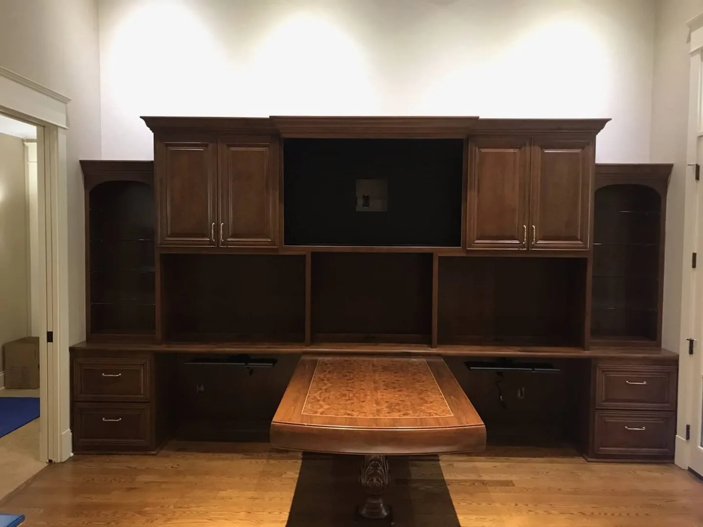 Dark stained custom built-in office wall unit with desk